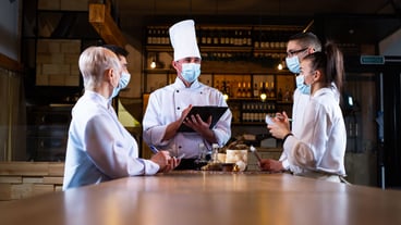 The chef conducts a briefing of employees in the restaurant