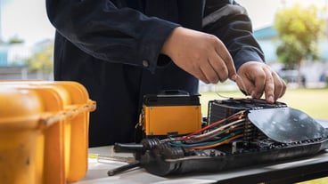 Engenheiros ou técnicos instalam linhas de cabos de fibra óptica para manutenção.