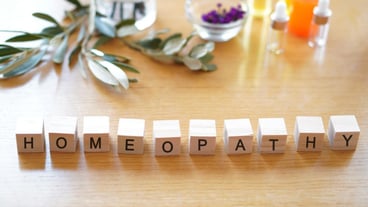 Homeopathy - words written on wooden blocks with herbal oil stethoscope