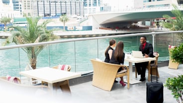 Group of positive stylish business people having a conversation at cafe terrace.