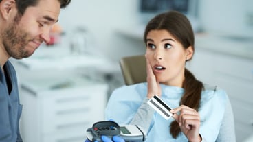 Adult woman paying for visit in dentist office