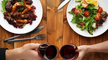 Man and woman hands holding red wine glasses in restaurant