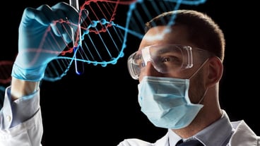 science, research and genetics concept - young scientist in safety glasses, face mask with test tube and virtual projection of dna molecule