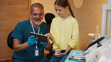 Smiling Dentist Showing Procedure On Tablet Screen