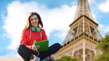 Technology, travel, tourism, music and people concept - smiling young woman or teenage girl with tablet pc computer and headphones over paris eiffel tower background