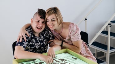 Disabled child doing sensory activity with sand rehabilitation