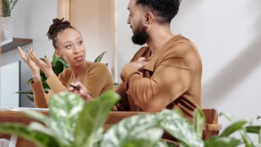 Young couple discussing family budget when sitting at table at home