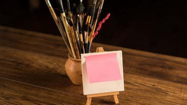 A small easel with a piece of paper and a brush on the table