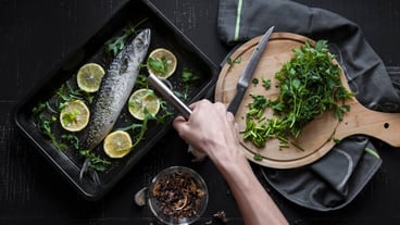 Crop hand cooking fish
