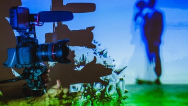a shadow of a camera man on a screen with newlyweds