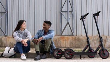 Couple using electric scooter for transportation