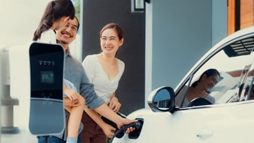 Progressive young parents and daughter living in a home with an electric car