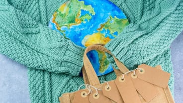 A bag with a world map on it sits on a green cloth.