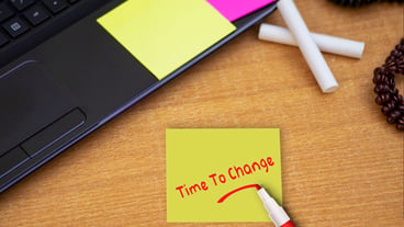 Time To Change sticky note pasted on the office table at the office