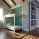 a bedroom with a bunk bed and a bookcase with a green wall