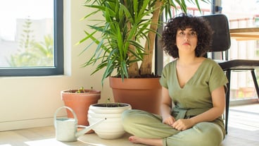 Young pretty woman with a watering can and plants