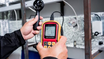 Technician use hand-held anemometer measuring air flowing measurement, wind speed and pressure.
