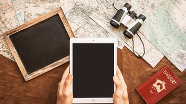 Hands with tablet at desk with maps