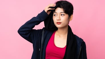 Young sport Asian woman over isolated pink wall with sport towel