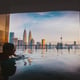 Man swimming in infinity pool against buildings
