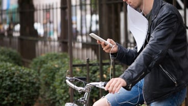 Center part of a man using a mobile phone while cycling.