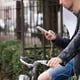 Center part of a man using a mobile phone while cycling.