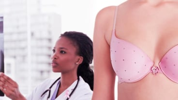Composite image of mid section of woman wearing pink bra for breast cancer social issue
