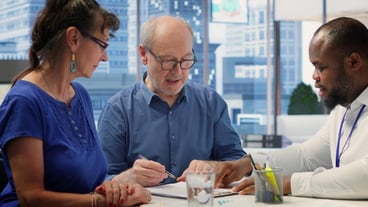 Senior people reading retirement plan contract terms with broker