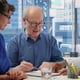 Senior people reading retirement plan contract terms with broker