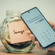 Counting saved up money dollars with mobile calculator toned image Female holding phone with calculator she already saved thousand dollars