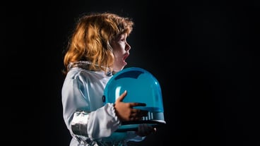 Closeup face of little astronaut with helmet looking dreamily Isolated background with copy space Kids imagining of space