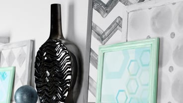 Modern vase with picture on shelf in room