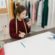 Professional beautiful Asian female fashion designer working with fabric sketches