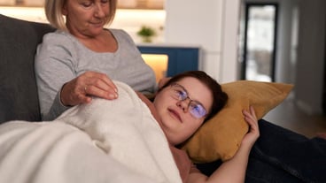 Mujer con síndrome de Down tumbada en un sofá hablando con su madre