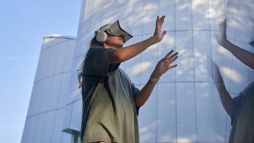 Low angle view of man with arms raised standing against sky