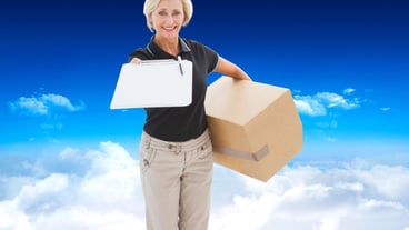 Happy delivery woman looking for signature against bright blue sky over clouds