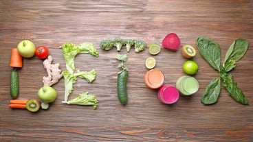The word DETOX made of ingredients and fresh juice in glasses on wooden background