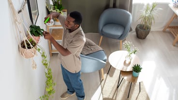 High angle man watering plants at home