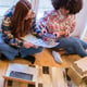 Two women entrepreneurs working together from home packaging their product to send to their homes Concept shipping teamwork business