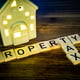 home property tax in wooden letters and a ceramic house with lights on
