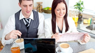 Joyful couple of businesspeople having breakfast in the kitchen