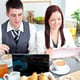Joyful couple of businesspeople having breakfast in the kitchen