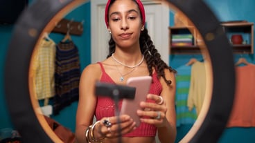 Young Blogger Standing In Front Of Ring Lamp