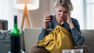 Depressed woman indoors at home mental health and alcohol addiction concept