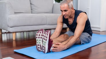 Active and fit senior man warmup and stretching before home exercising routine at living room while watching online fitness video Healthy lifestyle concept after retirement for pensioner Clout