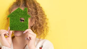 Happy home buyer A young girl holds a model of a greenhouse in her hands The concept of green energy ecology
