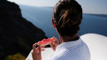 Close-up of woman eating watermelon while looking out to sea