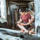 Young male mechanic sitting while writing a list of car repairs at a repair shop