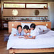 Family bedroom and tablet for watching movies in home streaming online and relax on website Parents daughter and morning wake up for cartoon or internet games ebook and storytelling for child