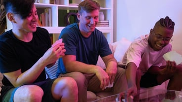 Men Sitting on the Couch while Playing Cards Stock Photo